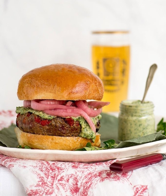 best burger recipes: lamb burger on a plate with a beer and sauce in the background