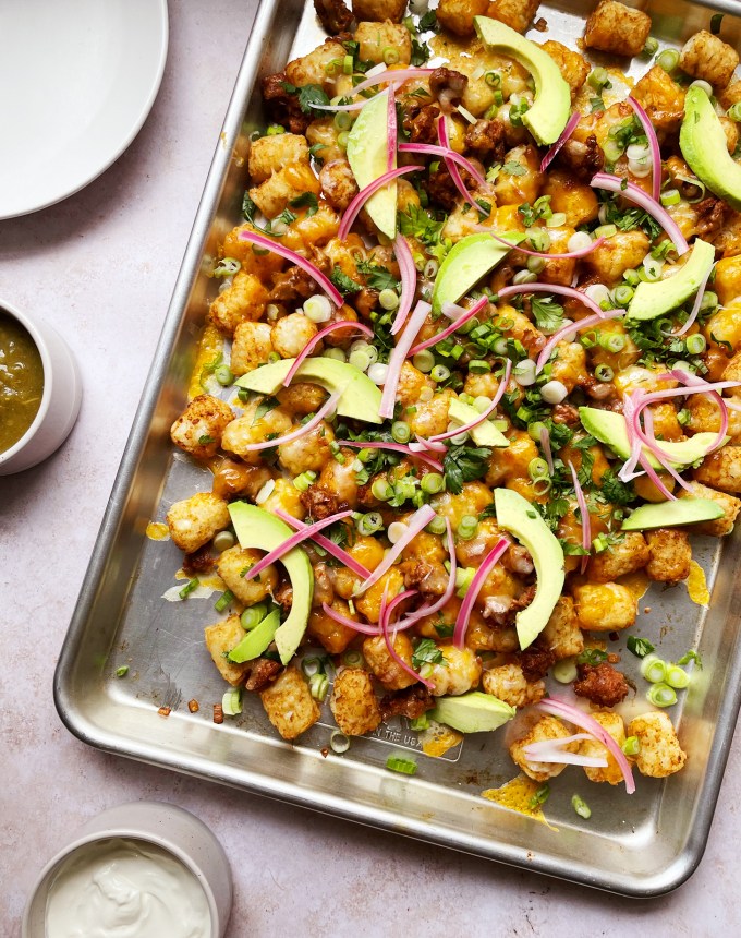 easy dinner recipes: sheet tray of tater tots topped with melted cheese, avocado, onions and cilantro