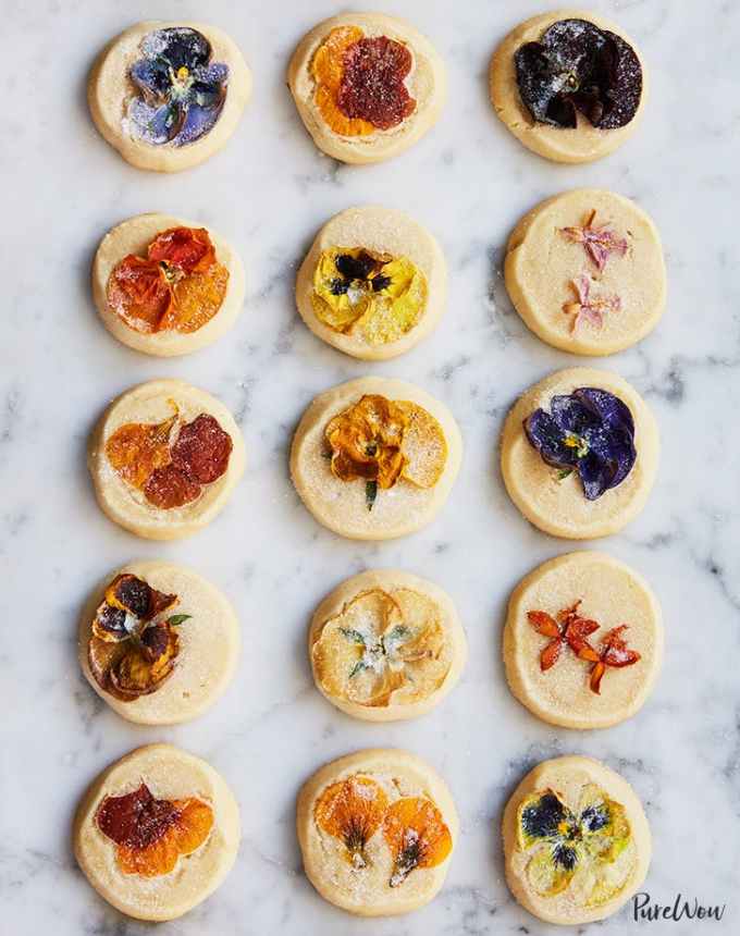 fun things to bake: 15 shortbread cookies topped with edible flowers on a marble counter