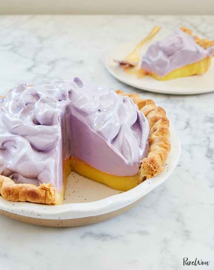 fun things to bake: lemon pie with blueberry meringue with a slice missing, with a slice on a plate in the background