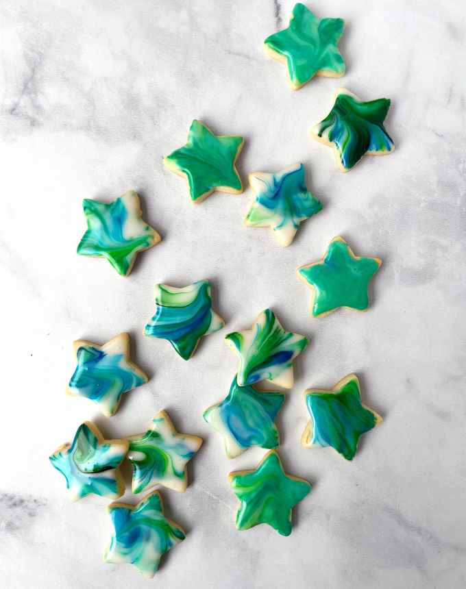 fun things to bake: aerial of star-shaped sugar cookies topped with marbled tie-dye glaze