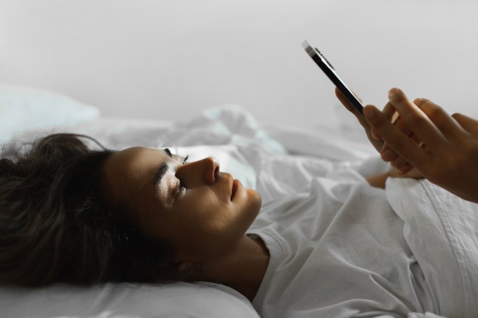 how to break up with someone woman laying in bed on her phone