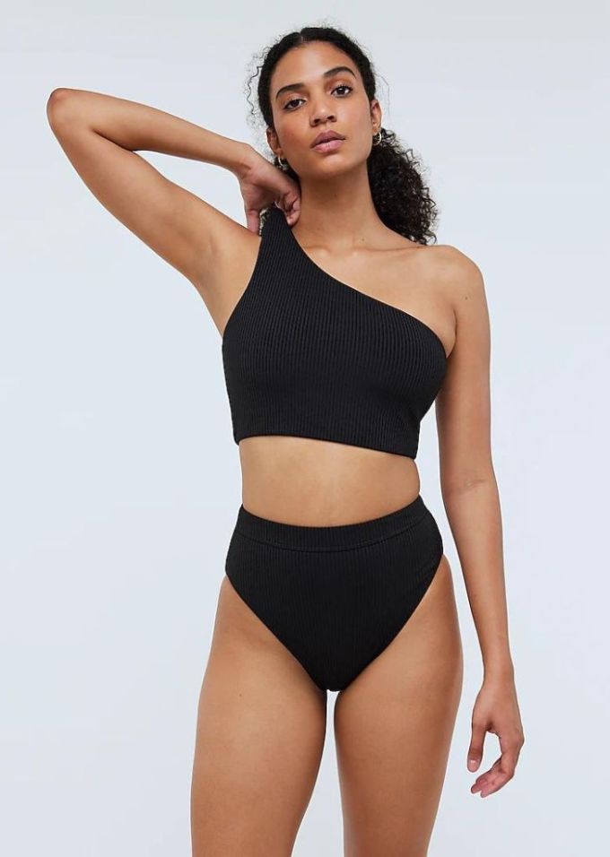 Black woman wearing high waisted black bikini with scooped top