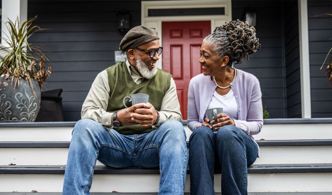 questions-for-couples: Senior Black couple having coffee in front of suburban home.