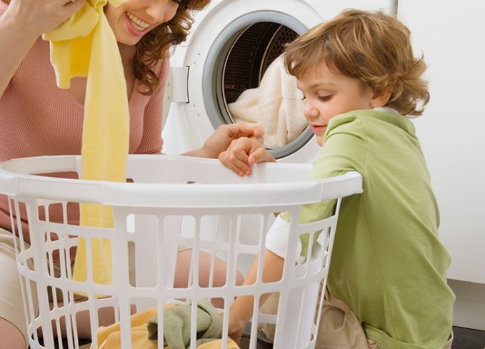 young boy doing chores and laundry at home
