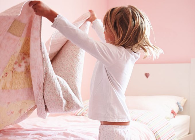 young girl making her bed